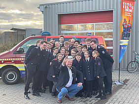 Ralf Schmidt, 1. Vorsitzender des Kreisjugendrings Schleswig-Flensburg, mit Kameradinnen und Kameraden der Jugendfeuerwehr Kappeln-Mehlby