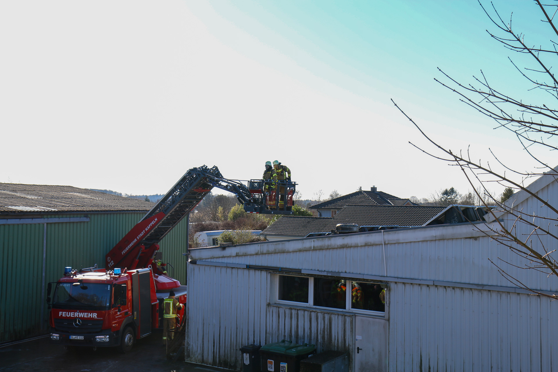 Einsatzkräfte im Drehleiterkorb prüfen die zuvor in Brand geratene PV-Anlage auf letzte Glutnester. Einsatzkräfte im Drehleiterkorb prüfen die zuvor in Brand geratene PV-Anlage auf letzte Glutnester.